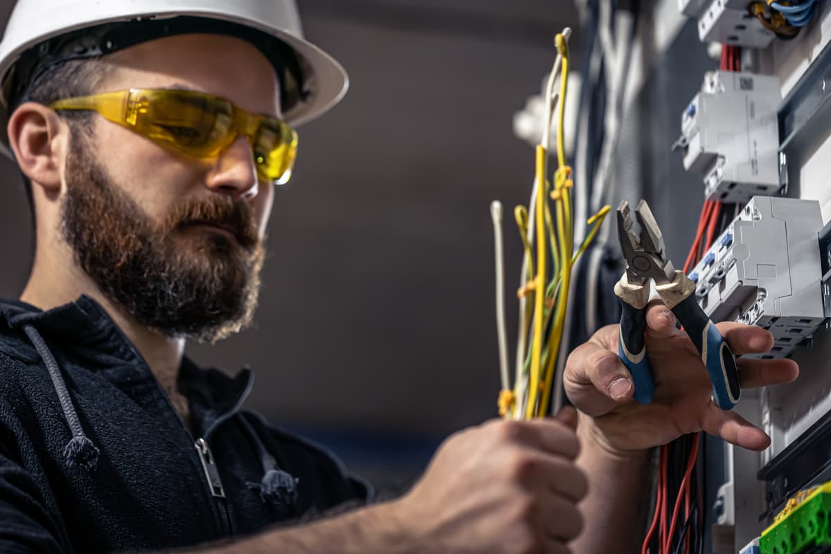 Electrician inspecting a switchboard for faults in Auckland — Electromech